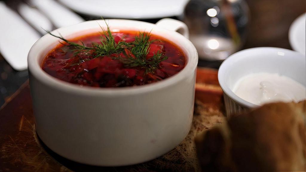 Borscht Soup · Flavorful beet, cabbage, carrot, and fresh herb soup. Served with sour cream and Georgian bread.