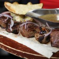 Mtsvadi · Skewer grilled Georgian shish-kebab made from organic meat. Served with baked potatoes, gril...