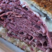 Corned Beef Reuben · Grilled rye, Swiss cheese, and sauerkraut. Served with coleslaw and pickle.