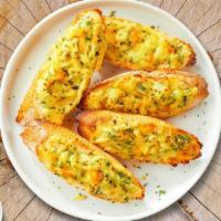 Cheesy Garlic Bread · Housemade bread toasted and garnished with butter, garlic, mozzarella cheese, and parsley.