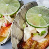 Pan Seared Fish Tacos · Tequila lime cilantro glaze and served with lime cabbage slaw, sour cream and guacamole.