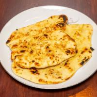 Garlic Naan · Pillowy soft naan bread glazed with garlic butter; served with a side of curry.