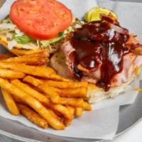 Backyard Bbq Burger · Topped with cheddar cheese, ham, bacon, and grilled onions served with BBQ sauce. Includes l...