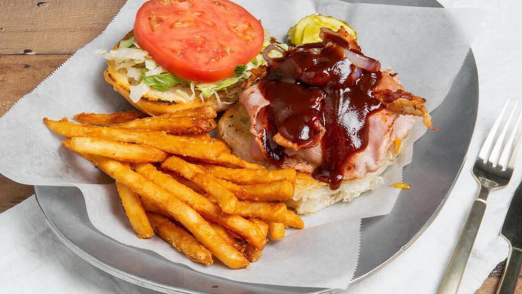 Backyard Bbq Burger · Topped with cheddar cheese, ham, bacon, and grilled onions served with BBQ sauce. Includes lettuce, tomato, onion.