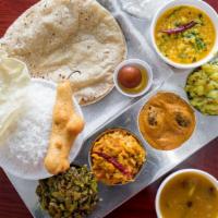 South Indian Vegetarian Thali  · Dal, two vegetable curries, pickle, papad, three pieces of roti or two pieces of poori, rasa...