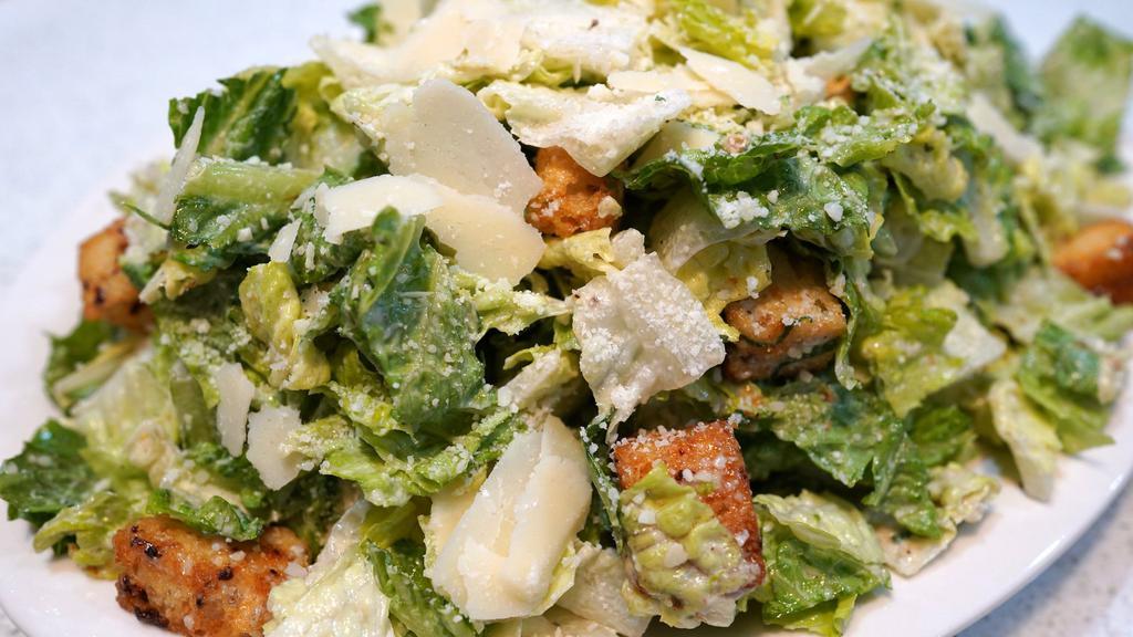 Caesar Salad · Baby romaine, shaved Parmigiano, homemade Caesar dressing, and croutons.