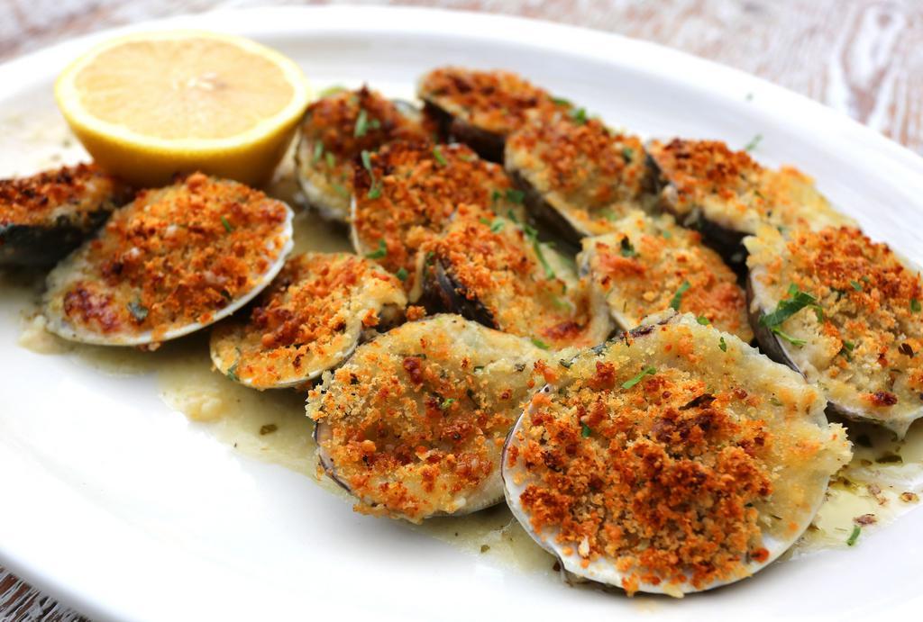 Baked Clams · Little neck clams stuffed with out house seasoned bread crumbs topped with Romano cheese baked in clam juice and until golden brown.