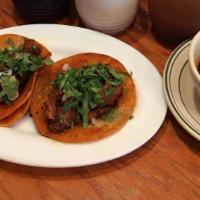 2 Birria Tacos- Beef · Beef simmer in Birria Sauce topped with cilantro and onion with a side of birria sauce.