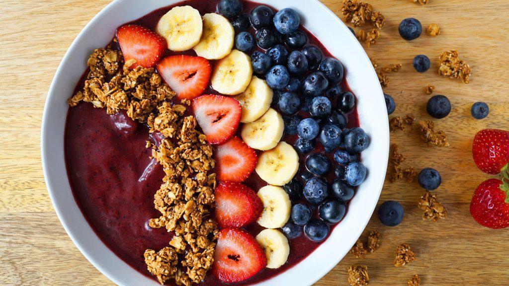 Açaí Bowl · Organic açaí, strawberries, blueberries, banana, and oat milk. Topped with seasonal berries, banana, coconut strips, and side of granola.