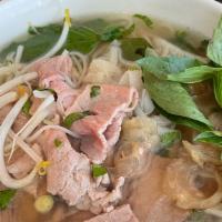 Steak & Tendon Pho · Beef broth with rice noodles, rare steak, and tendon. Garnished with onions, cilantro, green...