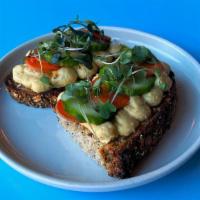 Hummus Toast · With pickled carrot and cucumber, garlic olive oil, herbed salt, microgreens. Served on seed...