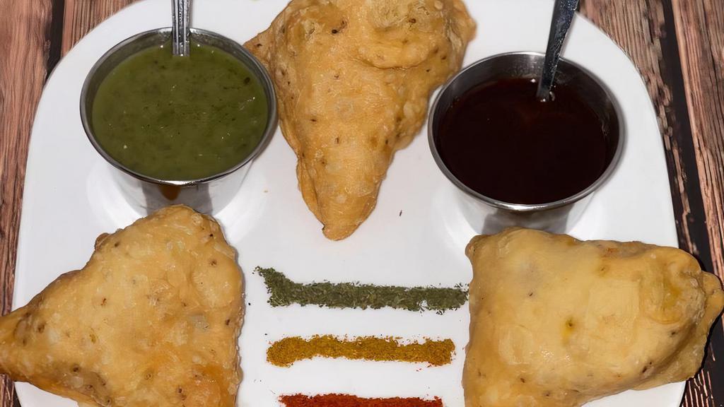 Vegetable Samosa (Three Pieces) · Deep-fried pastry with savory potato and cauliflower filling, served with mint and tamarind chutneys on the side.