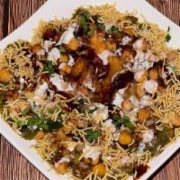 Samosa Chaat · Golden-brown turnovers topped with chickpeas, yogurt, and onions served with tamarind and co...