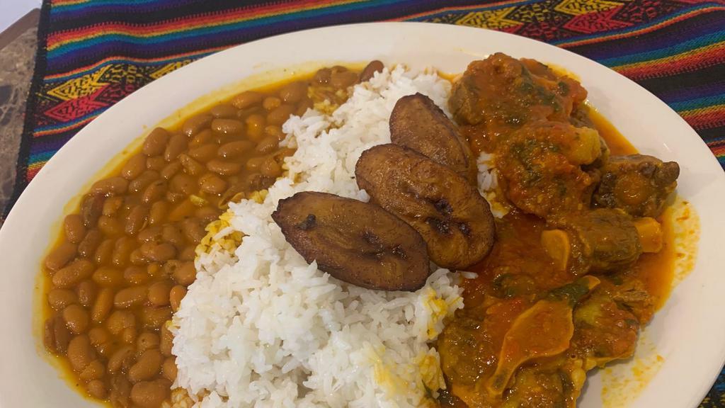 Oxtail Stew · Oxtail slow cooked with tomatoes, onions and peppers and fresh herbs. Served with rice beans and plantains.
