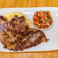 Carne Asada · Carne asada de 10 oz servida con arroz y salsa de tomate. / Grilled 10 oz carne asada served...