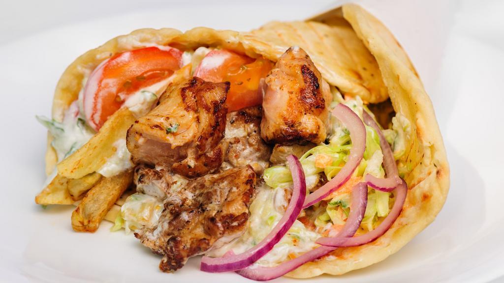 Chicken Shawarma Sandwixh · Our chicken shawarma is marinated in middle eastern seasonings and slow roasted throughout the day. Filled with chopped salad, and drizzled with famous white sauce.