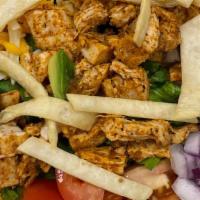 Baja Chicken Salad · Cajun chicken, Romaine, avocado, corn, jack & cheddar cheese, tomato, onions & tortilla stri...