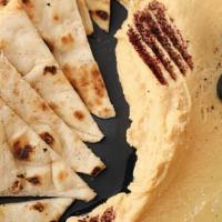 Hummus · Blend of ground garbanzo beans, tahini, and lemon. Served with two pita breads.
