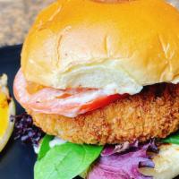 Crab Cake Sandwich · Homemade pan-fried crab cake with lettuce, tomatoes, and a lemon remoulade sauce on a brioch...