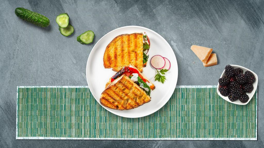 Veggie Delight Panini · Fresh mozzarella cheese with plum, tomatoes, and spinach sun-dried tomato spread on toasted bread.