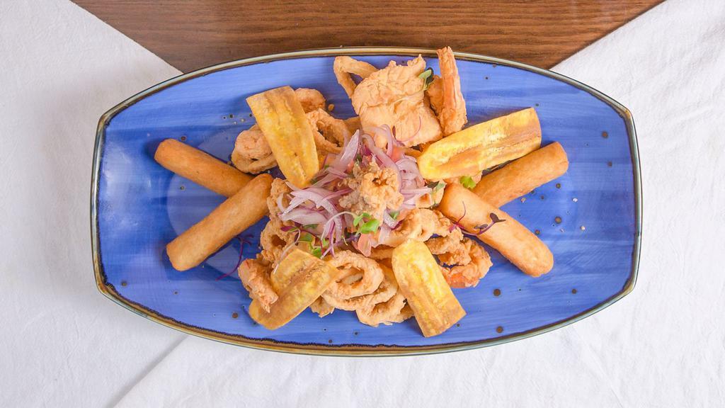 Jalea Oh! Calamares · A staple in Peruvian coastal cuisine. Our seafood variety including: Jumbo shrimp, calamari rings, grouper medallions, and mussels lightly seasoned and fried. Served with fried cassava plantain chips and salsa criolla