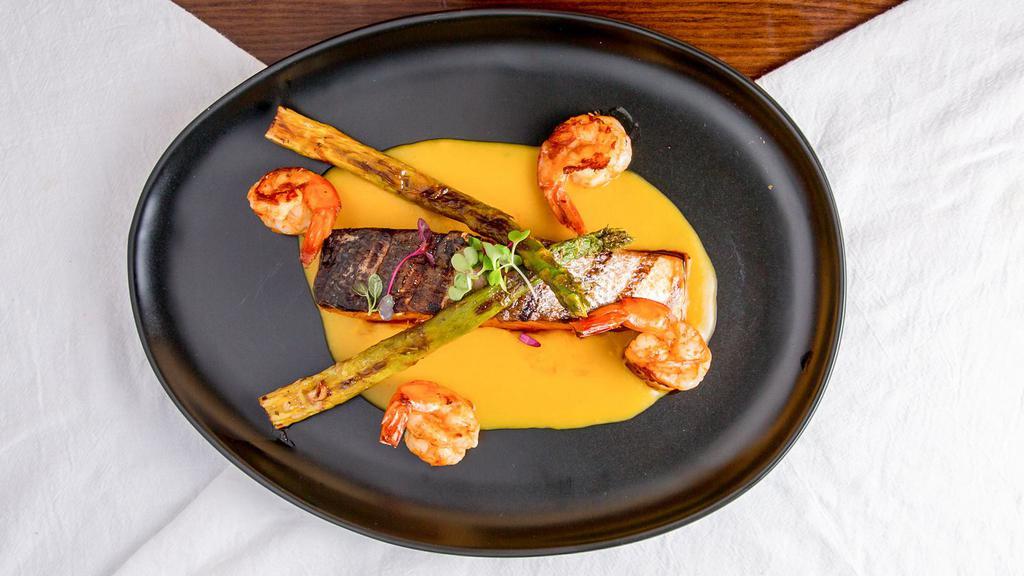 Salmon En Salsa De Pisco · A house creation! Wild caught Salmon fillet grilled to perfection served over an aji amarillo sauce, and topped with a grilled shrimp skewer
