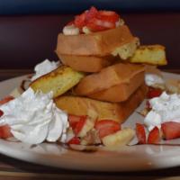 Waffle Tower · Layers of French toast & waffle quarters, topped with bananas, strawberries and walnuts, top...
