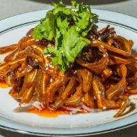 Pig Ear In Chili Oil · Thin, Tender Slices of Pig Ear Marinated in a Savory, Spicy, Numbing Sauce on a Bed of Thinl...