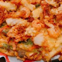 Seafood Scallion Jeon · Crispy pan-fried Scallion with topping of deep fried seafood - Crab meat, shrimp and squid