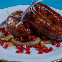 Kupati · Grilled spicy Georgian sausage topped with onions and pomegranate seeds