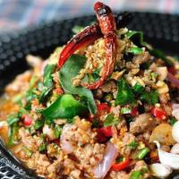 Larb Moo · Spicy minced pork salad with green vegetables and chilies.