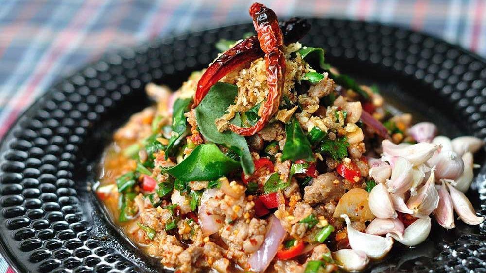 Larb Moo · Spicy minced pork salad with green vegetables and chilies.