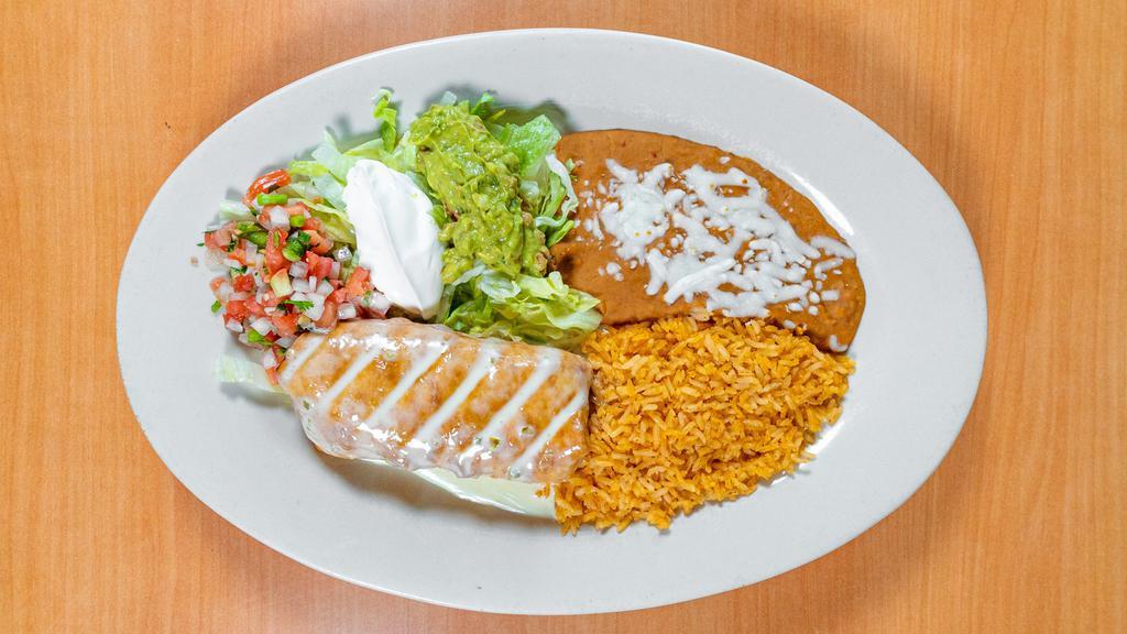 Chimichanga · A flour tortillas stuffed with your choice chunks of beef or spicy chicken, then deep fried to golden brown topped with cheese sauce. Served with lettuce, sour cream and pico de gallo, rice and beans.