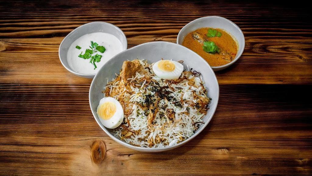 Hyderabadi Goat Biryani · Succulent Pieces of bone-in goat marinated overnight with Indian Herbs and spices then layered and Dum cooked with Basmati rice