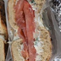 Bagel Addiction · Sliced lox, scallion cream cheese, tomato and onions on a butter bagel.