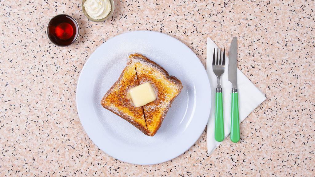 French Toast · Four slices of thick, egg-washed cinnamon bread served with maple syrup and powdered sugar.