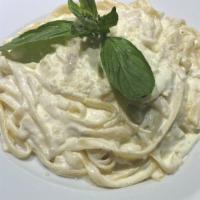 Fettuccine Alfredo · Fettuccine pasta in a creamy Alfredo sauce, topped with grated Parmesan cheese.