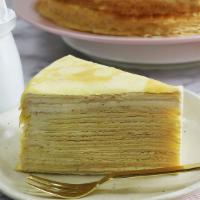 Mango Mille Crepe Cake · A slice of perfectly layered crepes with mango pastry cream.