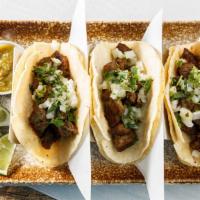 Carne Asada (Steak) Tacos · Soft corn tortillas stuffed with grilled steak, Spanish onions and fresh cilantro.