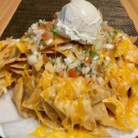Cheesy Nachos · Crunchy tortilla chips covered with melted cheese topped with pico de gallo & sour cream.