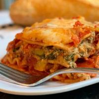 Homemade Lasagna · Layers of wide pasta noodles, natural ground beef, seasoned, old-fashioned ricotta cheese, m...