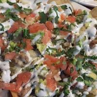 Nachos · Tortilla chips topped with beans, melted cheese, onion, cilantro, tomato, jalapeño and avoca...