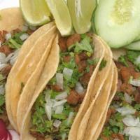 Tacos De Carne O De Pollo / Beef Or Chicken Tacos · Three tacos cubierta de cilantro, cebolla, pepino, rabano y limon. / 
3 and topped with cila...