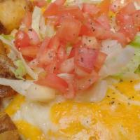 Huevos Rancheros · With layers of corn tortillas, beans, guacamole, red sauce, and melted cheese.