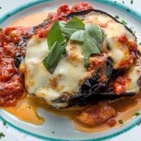 Parmigiana Di Melanzane · A tower of eggplant, tomato, basil, and mozzarella baked in our brick oven.