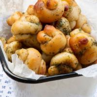 Garlic Knots (4) · Soft and fluffy knots of freshly baked dough topped with melted butter and garlic.
