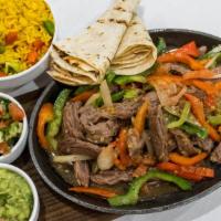 Sizzling Steak Fajitas · Juicy Steak with Peppers, Onions, and Tomatoes. Served Tableside over Yellow Rice.