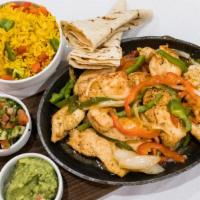 Sizzling Chicken Fajitas · Seasoned Chicken Breast, with Peppers, Onions, and Tomatoes. Served Tableside over Yellow Ri...