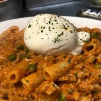 Rigatoni Burrata · Rigatoni tossed with ground sweet sausage and peas in a creamy pink sauce topped with Burrata.