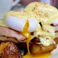 Eggs Benedict · Canadian bacon, poached eggs and hollandaise over an English muffin, with home fries.
